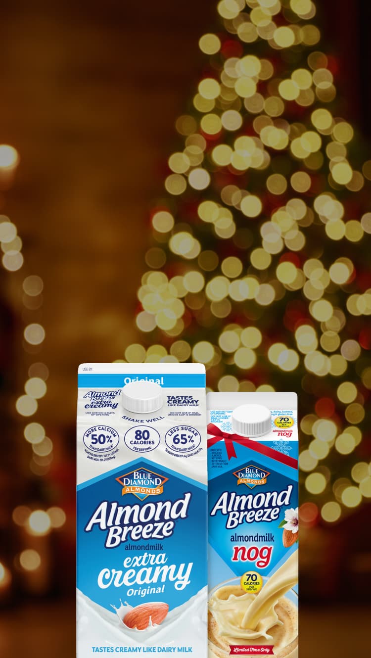 Almond Breeze cartons in front of a Christmas tree and fireplace