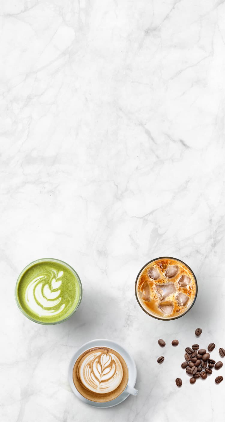 Top-down view of coffee cups with intricate designs on a marble surface