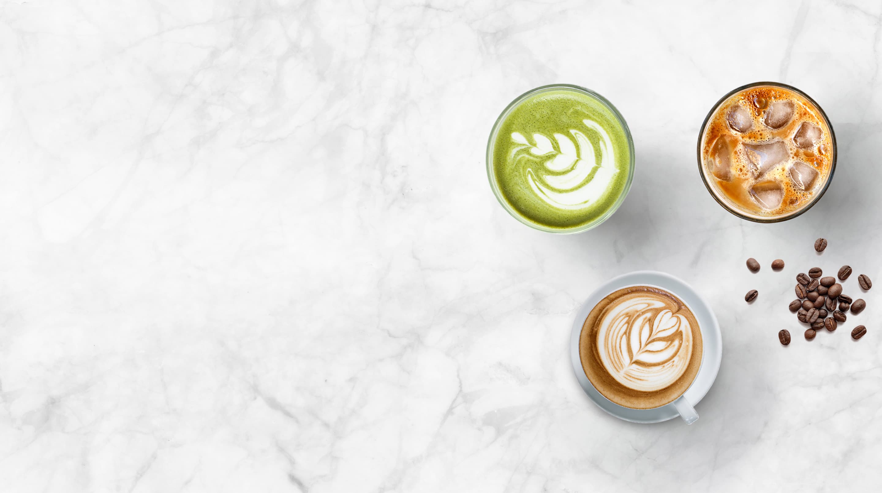 Top-down view of coffee cups with intricate designs on a marble surface